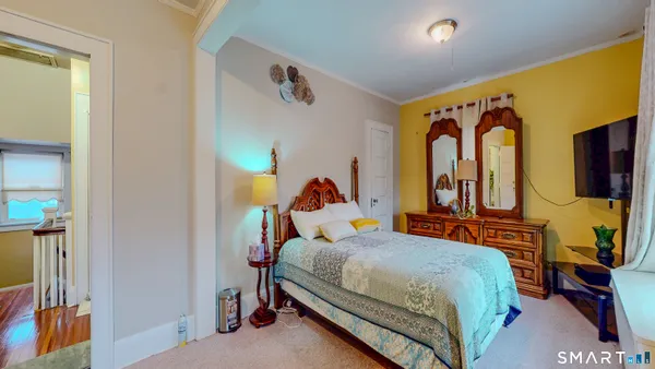 a bedroom with a bed and a painting on the wall