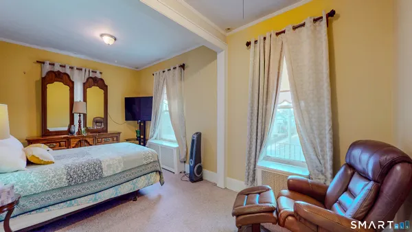a bedroom with a bed couch and a window