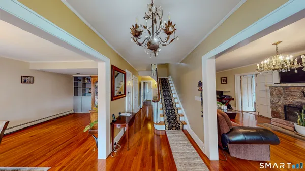 a view of a hallway with furniture and chandelier