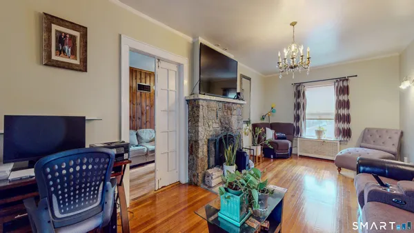 a living room with furniture a fireplace and a chandelier