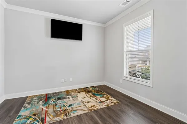 a living room with furniture kitchen view and a wooden floor