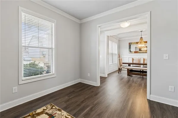 a living room with stainless steel appliances furniture and a kitchen view