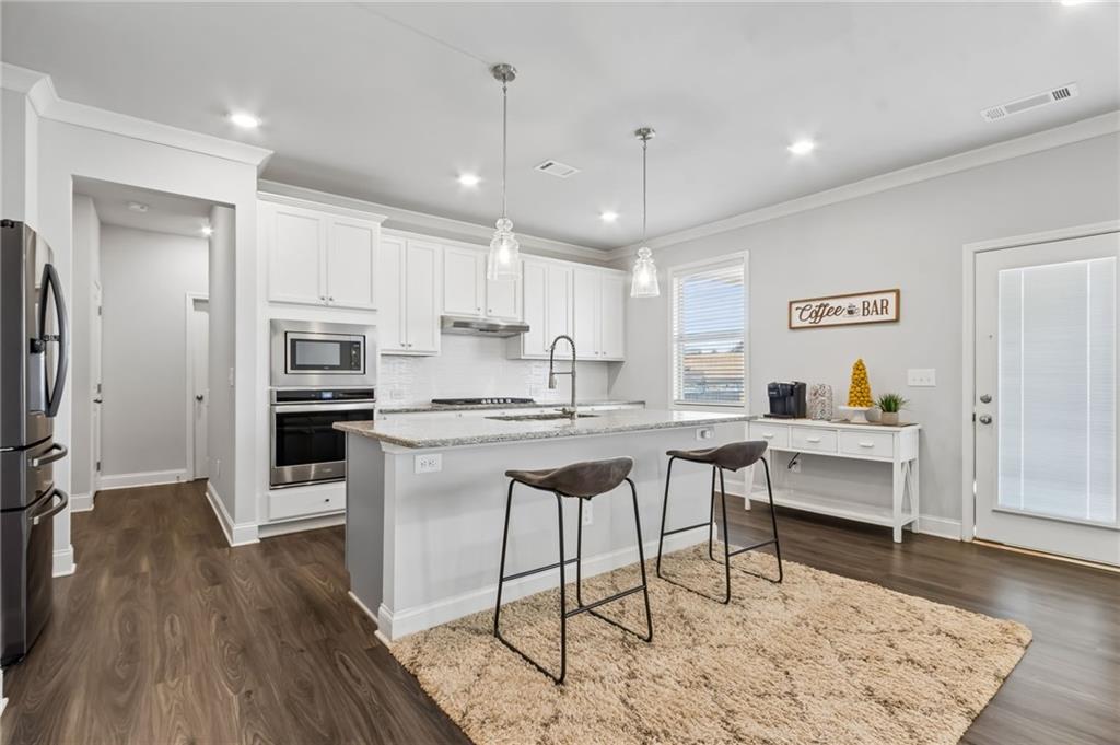 4417 Chestnut Oak Way Gainesville, GA 30504 - Photo 30 of 63 a kitchen with stainless steel appliances kitchen island granite countertop a refrigerator and a stove top oven