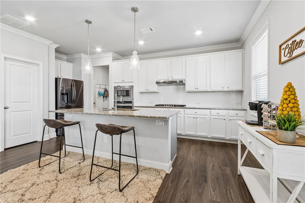 4417 Chestnut Oak Way Gainesville, GA 30504 - Photo 31 of 63 a kitchen with stainless steel appliances kitchen island granite countertop a stove a sink and a refrigerator