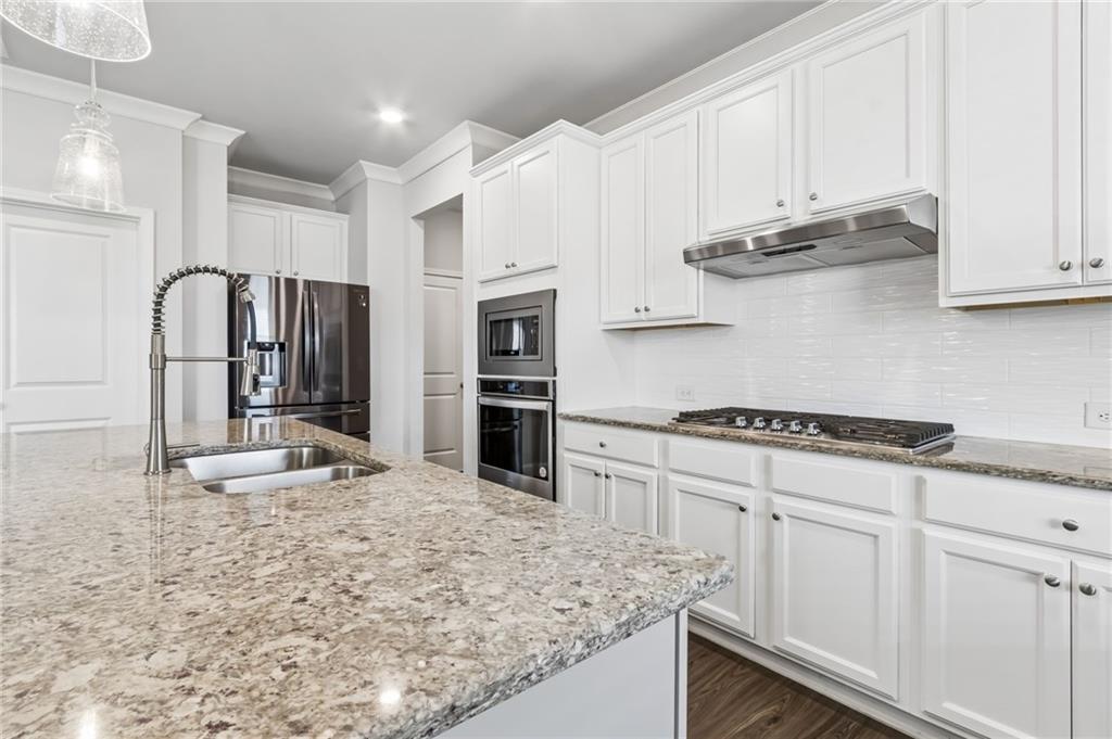 4417 Chestnut Oak Way Gainesville, GA 30504 - Photo 32 of 63 a kitchen with stainless steel appliances granite countertop a sink stove and refrigerator