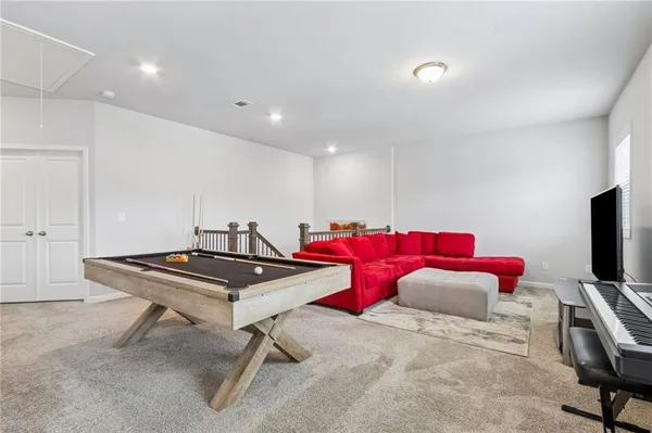 a bedroom with a bed a table and large windows