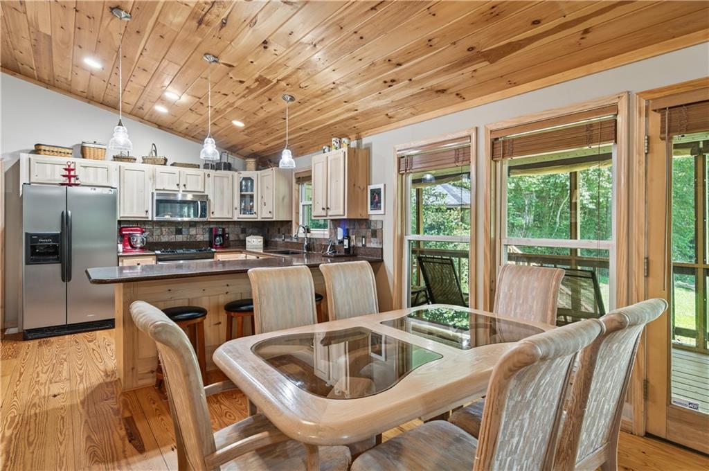200 Bahn Innsbruck Helen, GA 30545 - Photo 9 of 27 a kitchen with stainless steel appliances granite countertop a sink dishwasher a refrigerator a microwave oven with a dining table and chairs with wooden floor