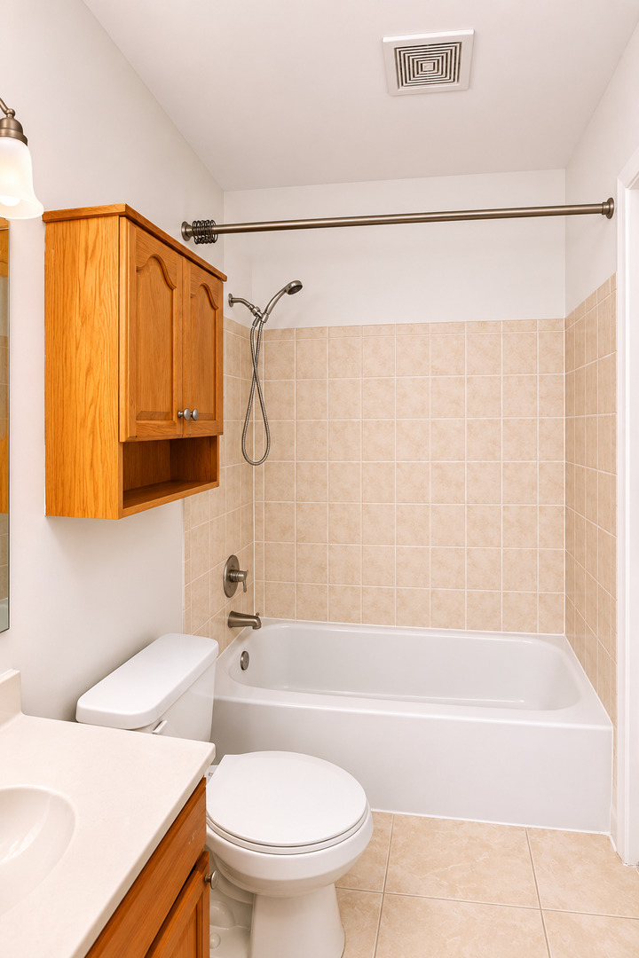 707 Sunfish Point, Unit 707 Schaumburg, IL 60194 - Photo 18 of 20 a bathroom with a sink a toilet and a bathtub