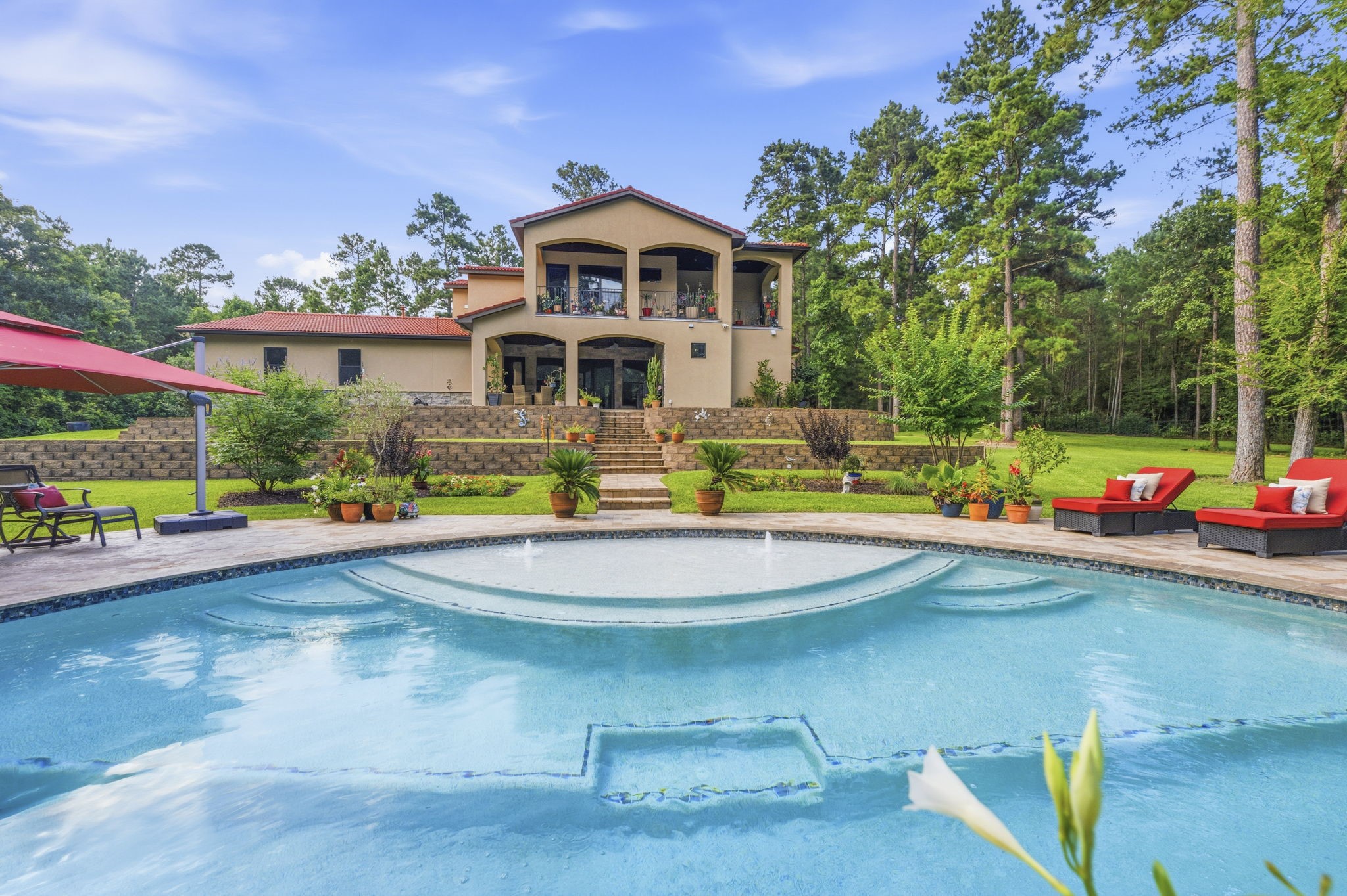 280 Sundog Road Huntsville, TX 77340 - Photo 41 of 50 Beautiful view of the rear elevation showcasing the balconies, covered patio, and steps leading down to the stunning pool.