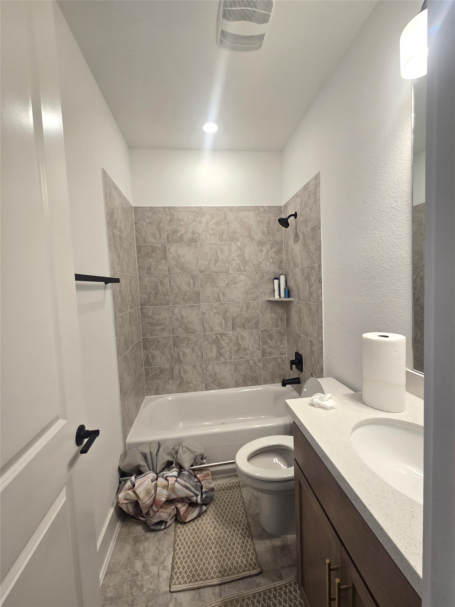124 Ribera Drive Liberty Hill, TX 78642 - Photo 26 of 40 Tiled bath and shower area provides a sleek, easy-to-maintain space in this clean bathroom.