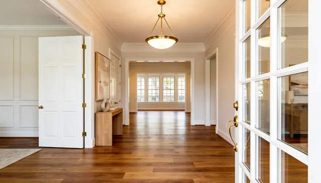 a view of a big room with wooden floor and windows