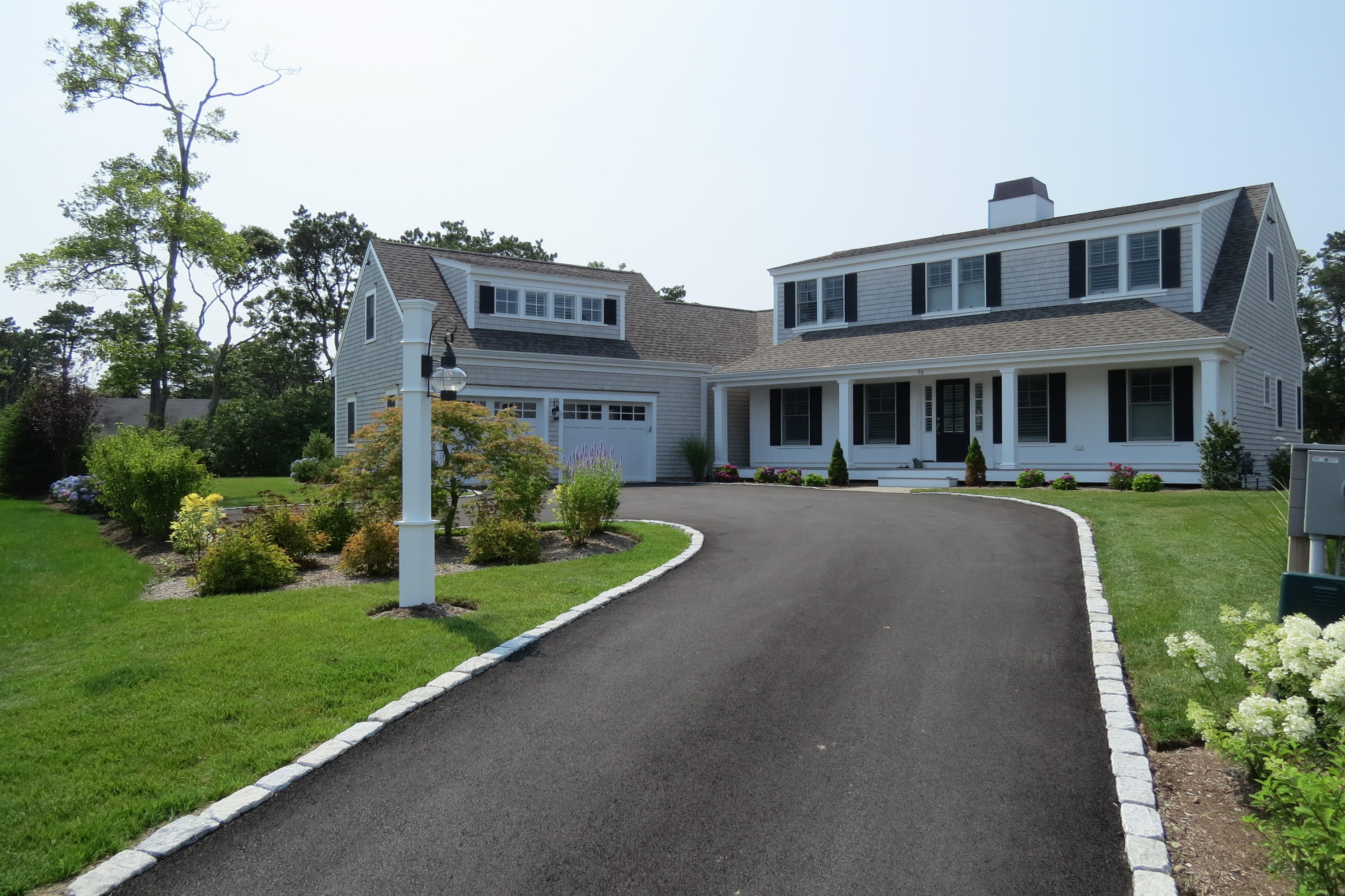 96 Hunter Rise Chatham, MA 02633 - Photo 2 of 37 a front view of a house with a yard table and chairs
