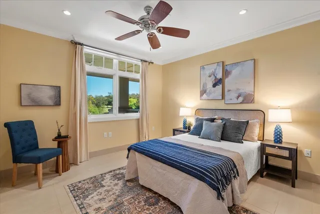 a bedroom with a bed a chair and a potted plant