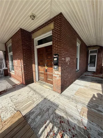 a view of a house with a barbeque and wooden stairs