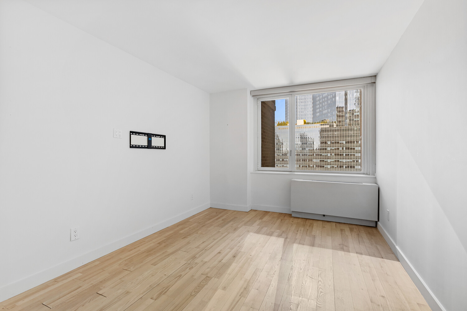 322 West 57th Street, Unit 38D1 Manhattan, NY 10019 - Photo 5 of 6 an empty room with wooden floor and windows