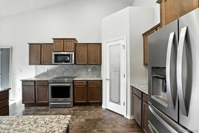 a kitchen with stainless steel appliances granite countertop a refrigerator and a sink
