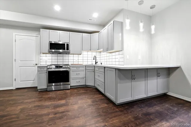 a view of kitchen with stainless steel appliances granite countertop a white cabinets and a fireplace