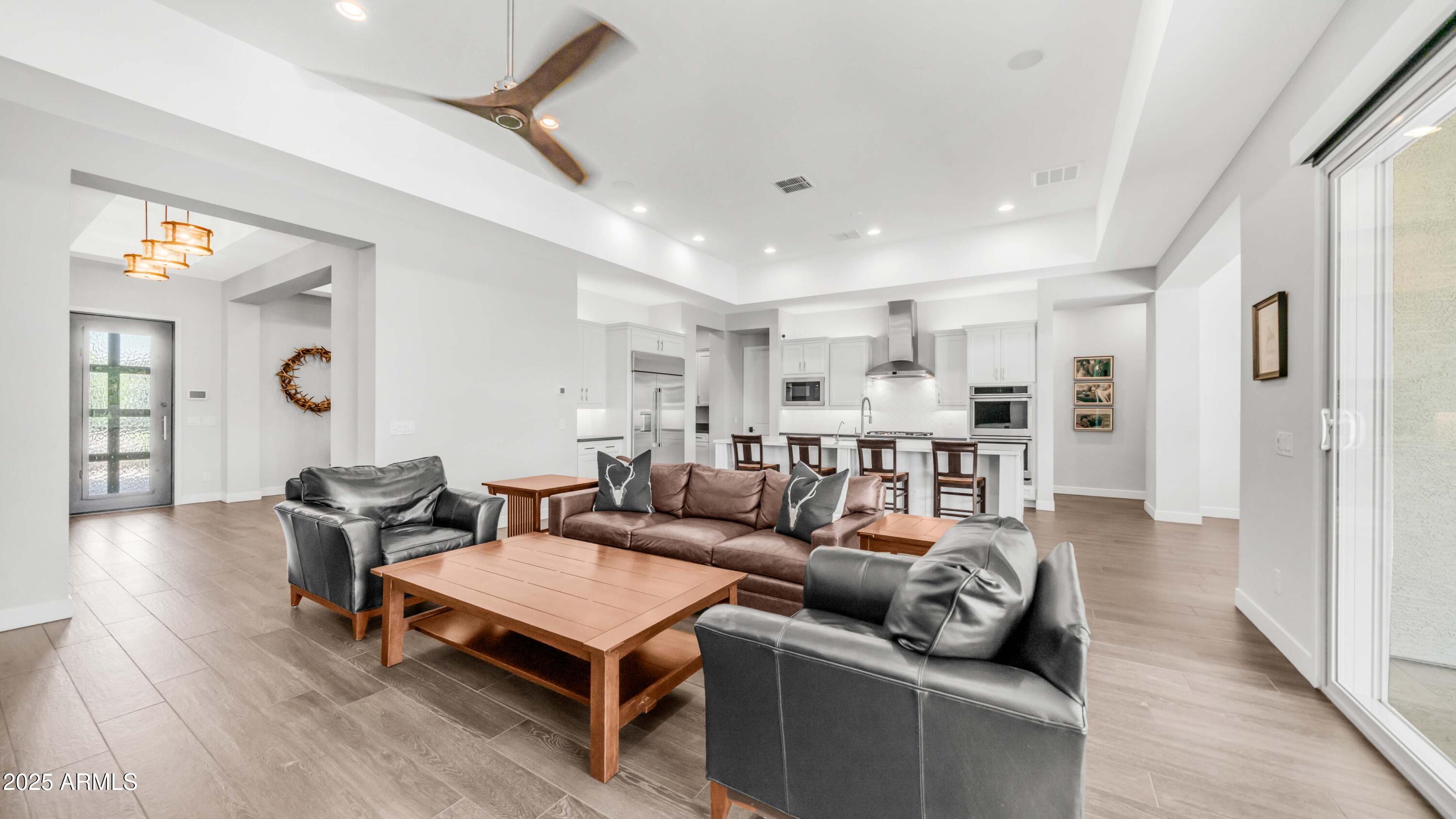 2086 East Trigger Way Gilbert, AZ 85297 - Photo 43 of 69 a living room with furniture a wooden floor and a chandelier