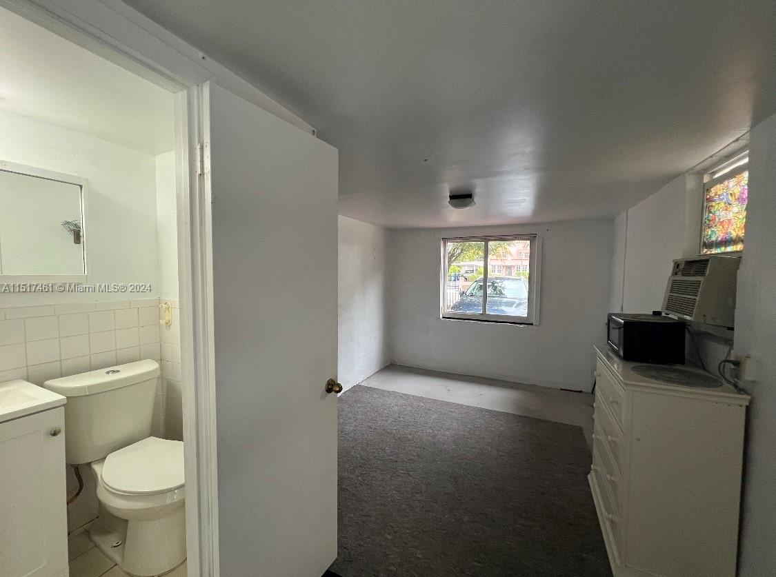 2675 Southwest 24th Terrace Miami, FL 33145 - Photo 14 of 17 a bathroom with a toilet sink a mirror and a window