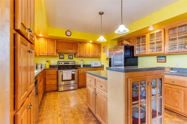 a kitchen with stainless steel appliances granite countertop a stove a sink and a refrigerator