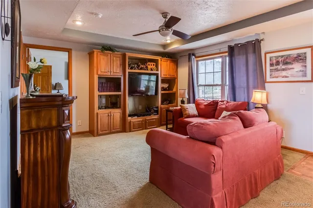 a living room with furniture a ceiling fan and a window