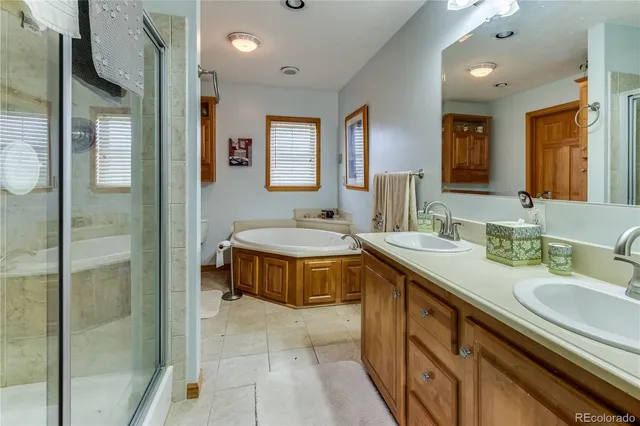 a spacious bathroom with a double vanity sink a mirror and a shower