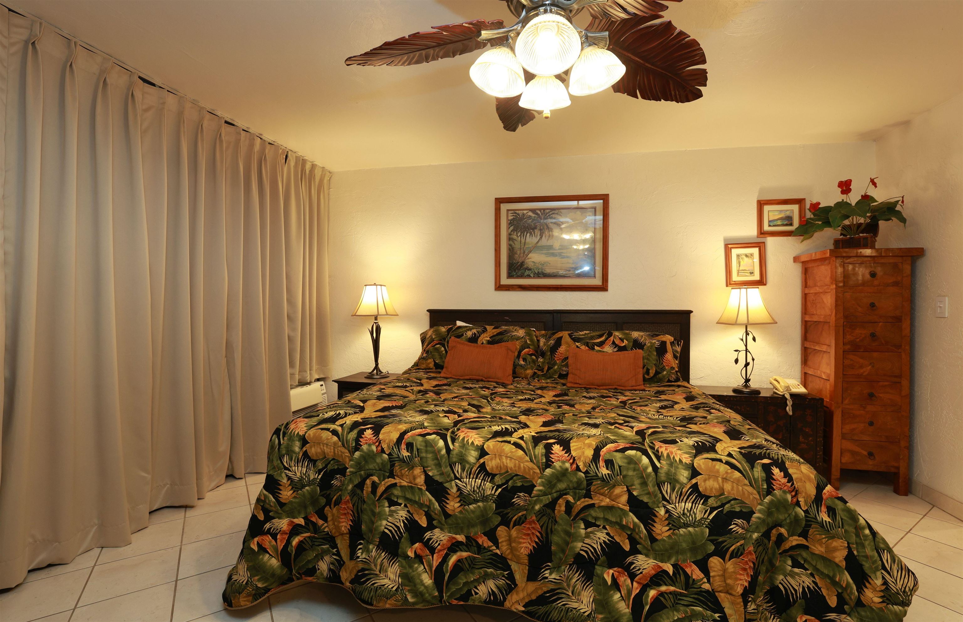 3543 Lower Honoapiilani Road, Unit C107 Lahaina, HI 96761 - Photo 20 of 49 a bed sitting in a bedroom next to a window and a chandelier