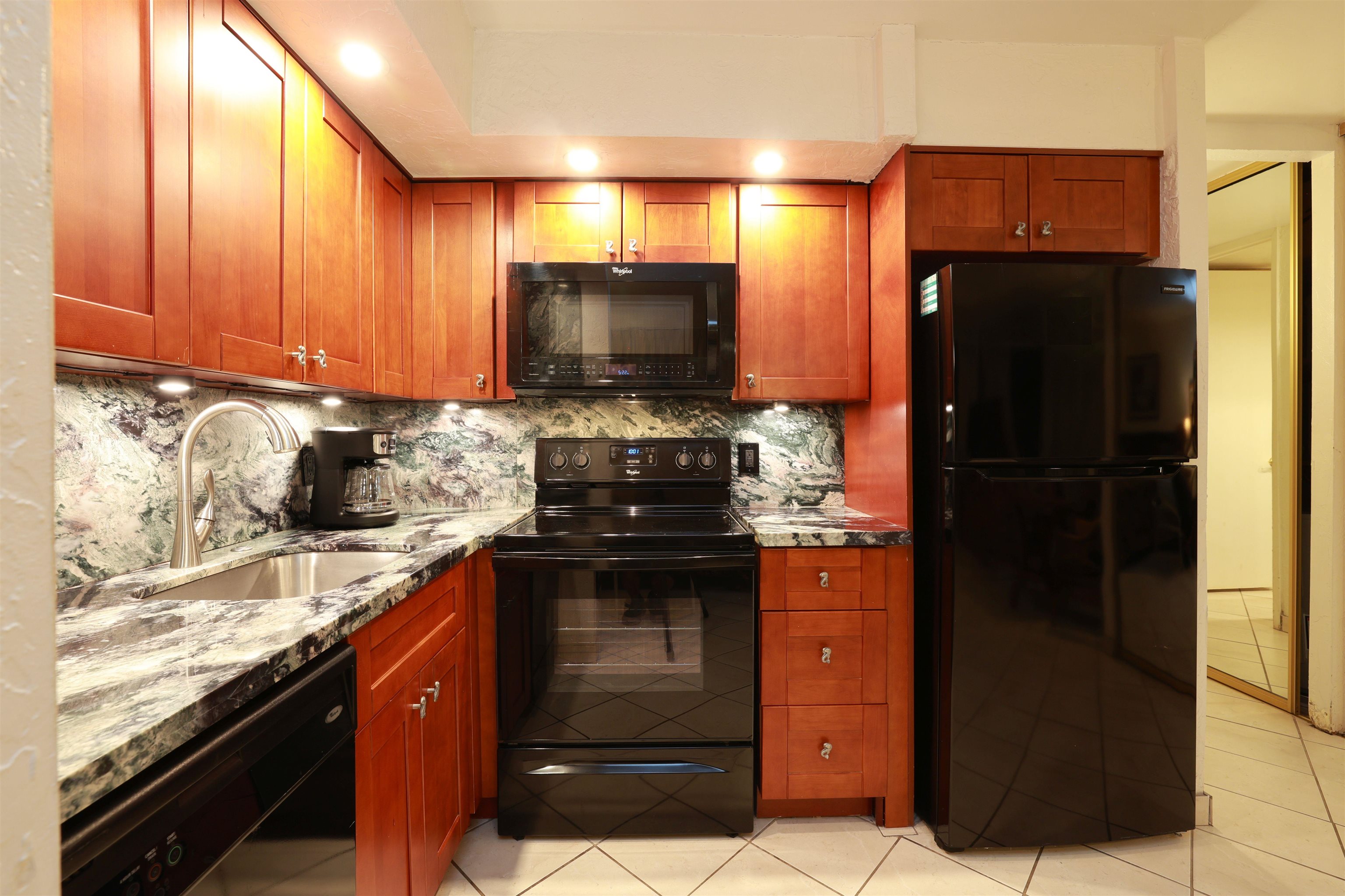 3543 Lower Honoapiilani Road, Unit C107 Lahaina, HI 96761 - Photo 26 of 49 a kitchen with a refrigerator stove and cabinets