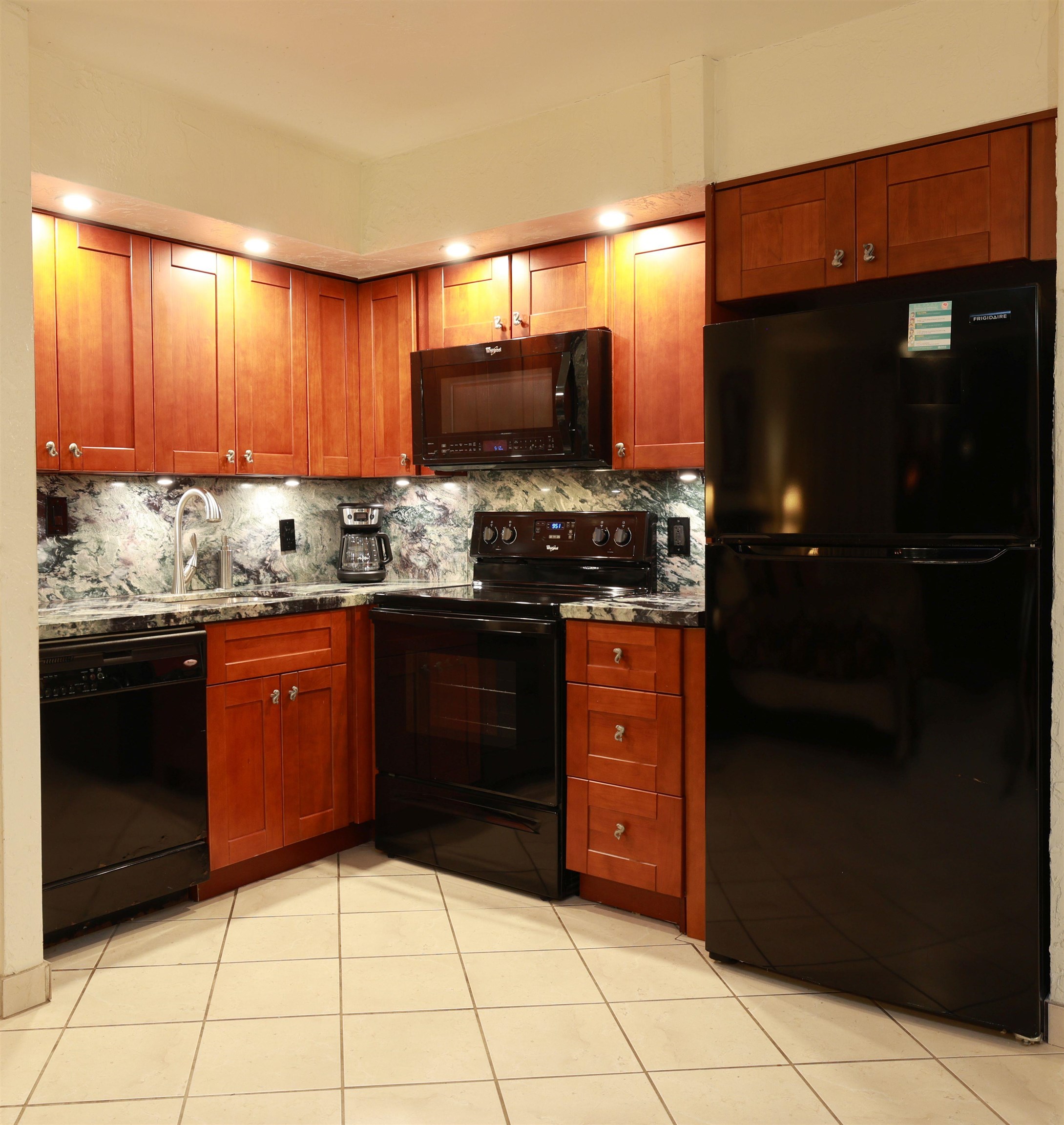 3543 Lower Honoapiilani Road, Unit C107 Lahaina, HI 96761 - Photo 5 of 49 a kitchen with stainless steel appliances granite countertop a stove a sink and a microwave