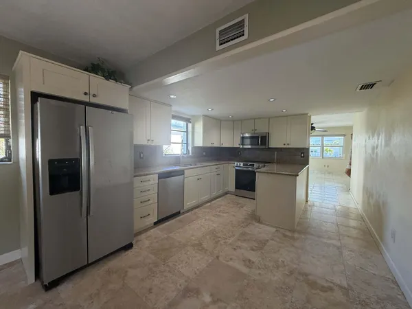 a large kitchen with cabinets and stainless steel appliances
