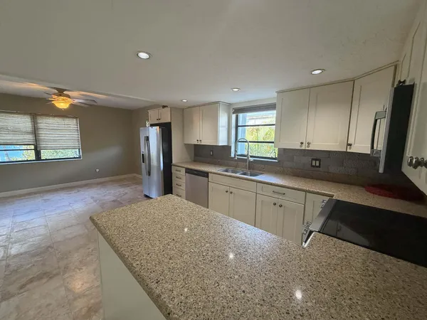 a kitchen with stainless steel appliances granite countertop a sink stove and cabinets