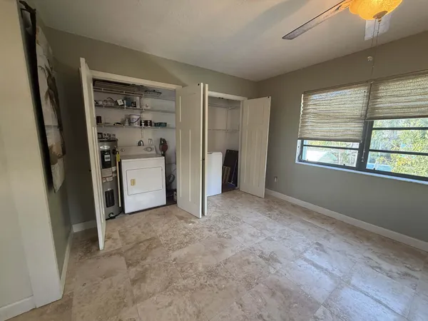 an empty room with closet and windows