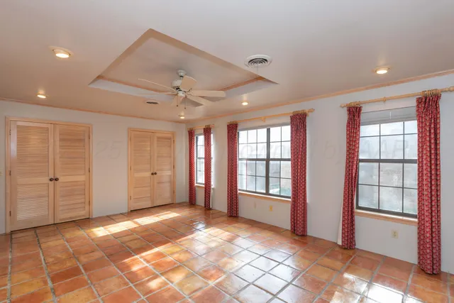 a view of an empty room with window and cabinet