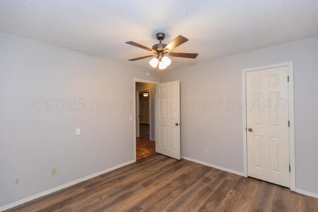 a view of a room with a ceiling fan and a fan