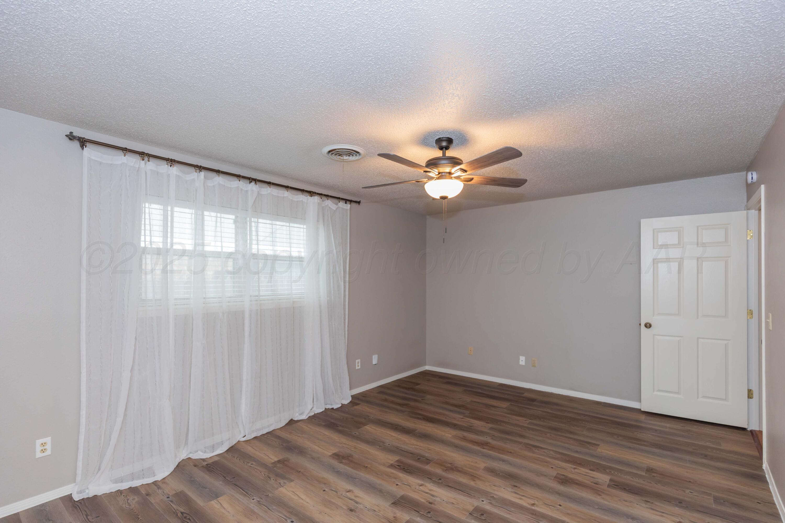 1031 Cimarron Trail Canyon, TX 79015 - Photo 39 of 50 a view of an empty room with wooden floor and a window