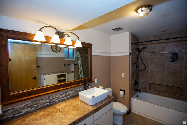 1500 Sumac Drive Logan, UT 84321 - Photo 33 of 42 Full bathroom featuring a wood-framed mirror, a rectangular vessel sink with a dark faucet, and a tiled countertop