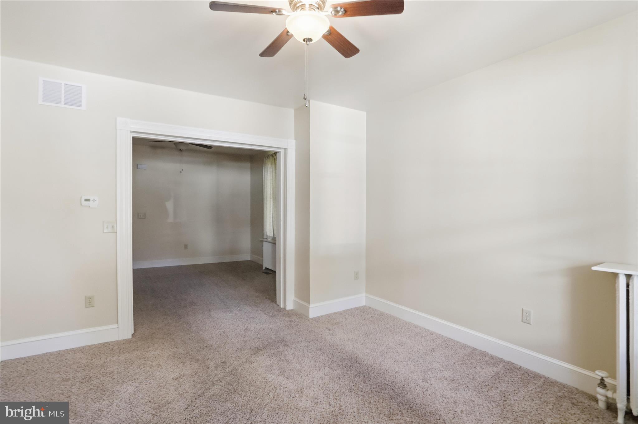 438 Chestnut Street Cumberland, MD 21502 - Photo 25 of 36 an empty room with a chandelier fan and a ceiling fan
