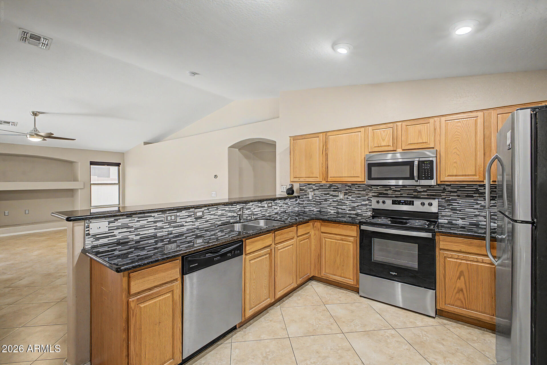 2340 West Apollo Road Phoenix, AZ 85041 - Photo 7 of 26 a kitchen with stainless steel appliances granite countertop a stove sink and cabinets