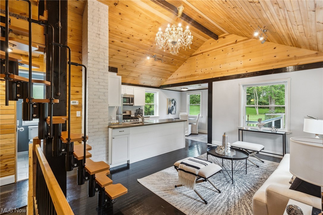 27250 Cannon Road Solon, OH 44139 - Photo 3 of 15 Hardwood floored living room with brick wall, a chandelier, wooden ceiling, lofted ceiling with beams, and a high ceiling