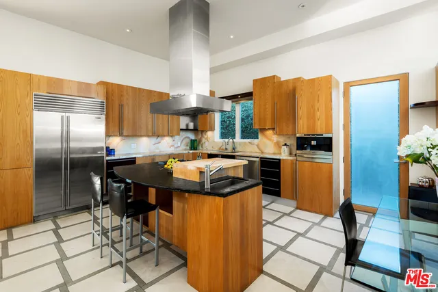 a kitchen with stainless steel appliances granite countertop a sink a stove and a refrigerator
