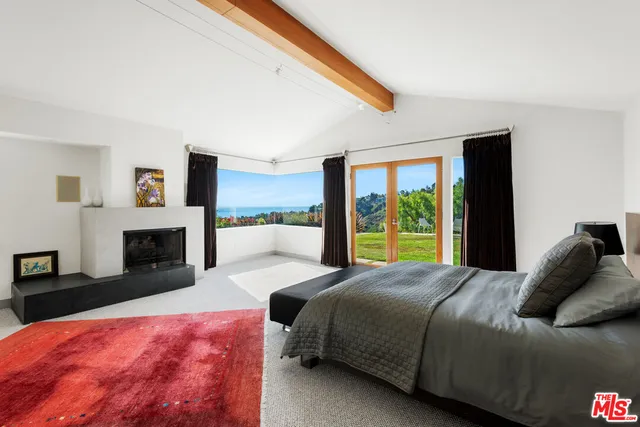 a bedroom with a large bed and a fireplace