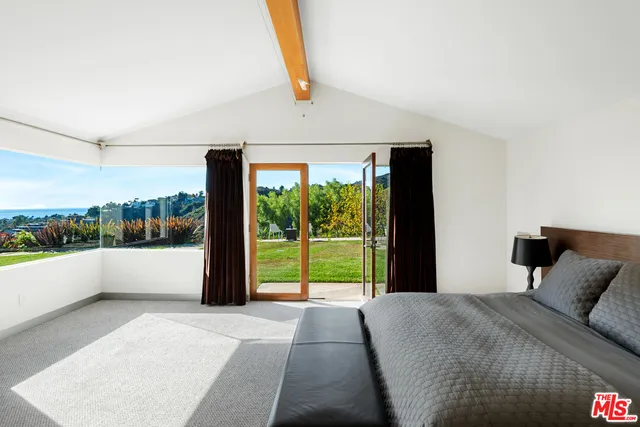 a bedroom with a bed and large window