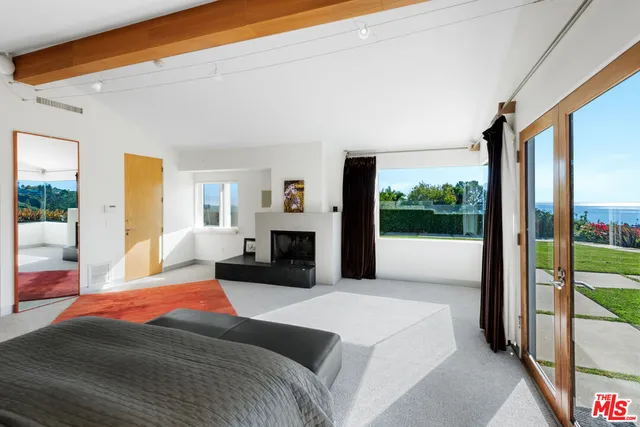 a spacious bedroom with a large bed and a balcony view
