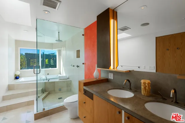 a bathroom with a granite countertop sink toilet and mirror
