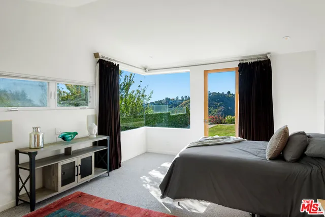 a bedroom with a bed and a large window