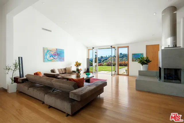 a living room with furniture floor to ceiling window and a flat screen tv