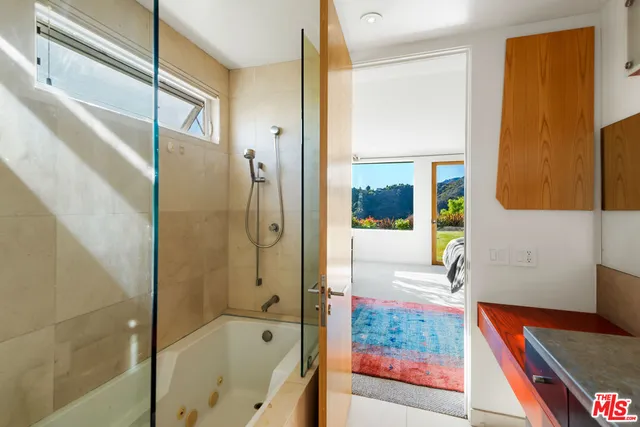 a bathroom with a tub shower and sink