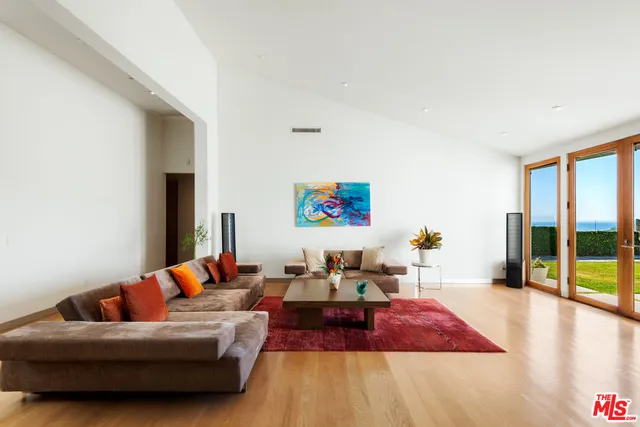a living room with furniture and a floor to ceiling window