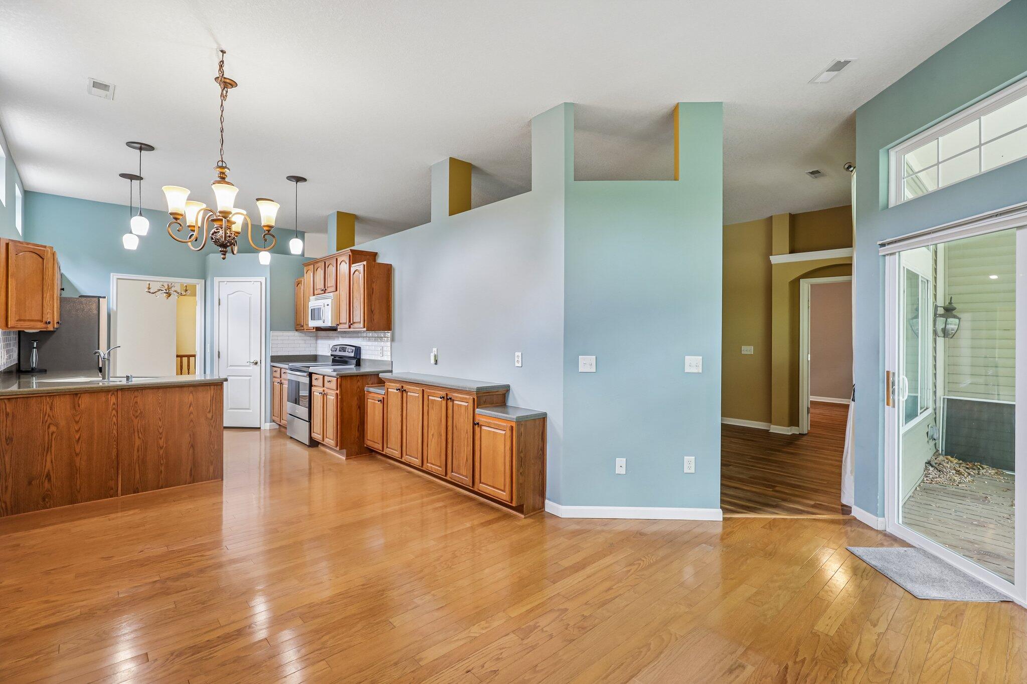 876 Flint Ridge Newport, KY 41076 - Photo 3 of 43 Spacious open-concept living area featuring wood-finish flooring, a kitchen with wood cabinetry, stainless steel appliances, and a tile backsplash
