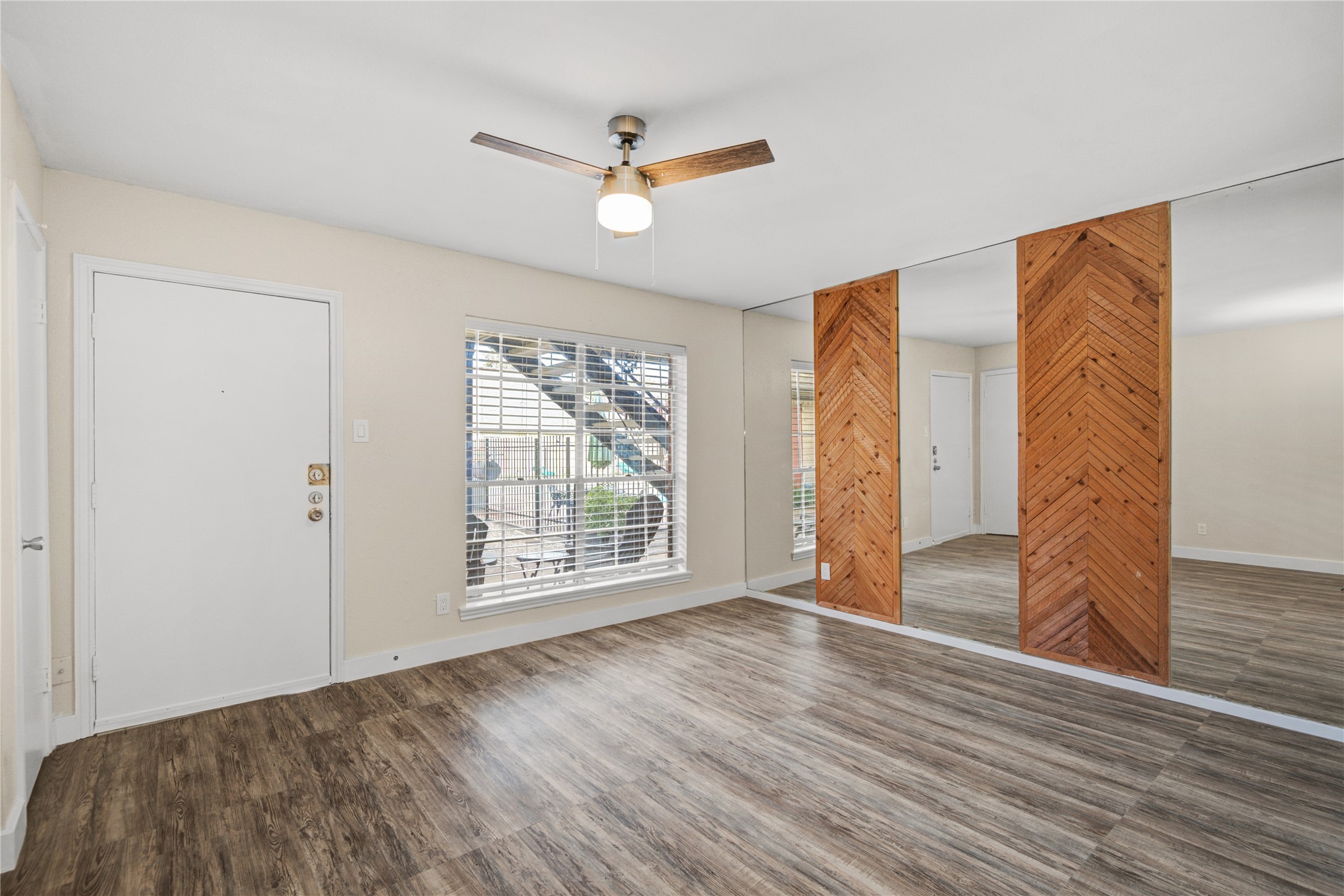 11540 Chimney Rock Road, Unit 117 Houston, TX 77035 - Photo 11 of 38 a view of an empty room with wooden floor and a window